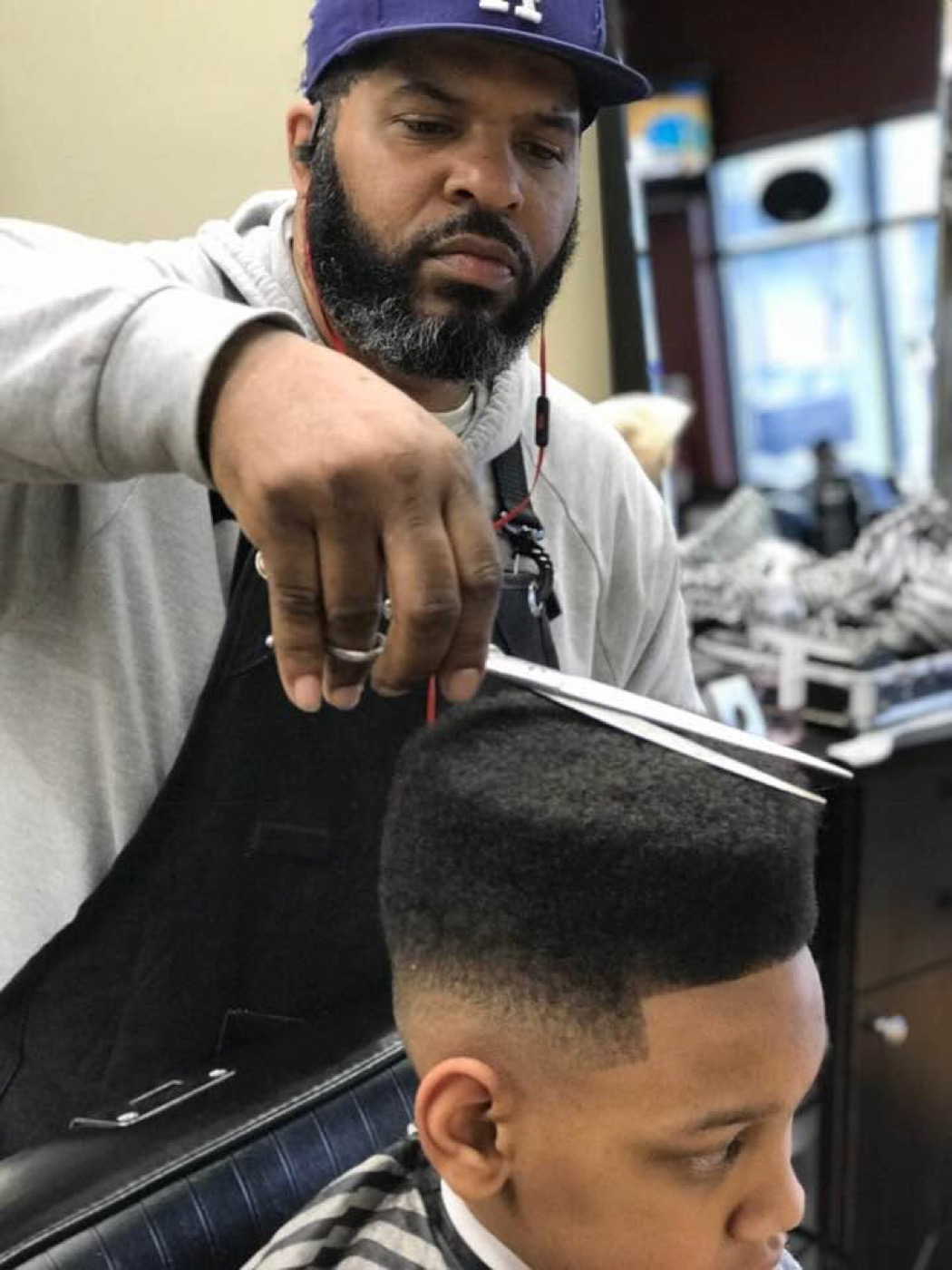 Teon cutting a client's hair at Precision Barber Lounge